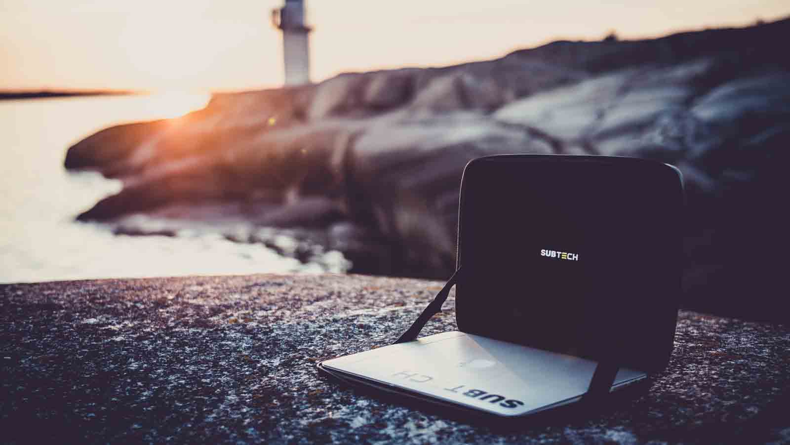 Wasserdichte Laptop-Tasche mit Notebook am Meer bei Sonnenuntergang – robuster Laptop-Schutz für Outdoor-Abenteuer, Reisen, Bootstouren, Camping und mobiles Arbeiten in jeder Umgebung.