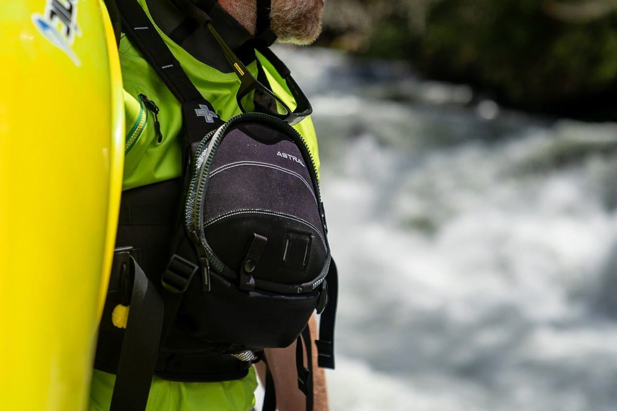 Detailansicht der Astral GreenJacket Rettungsweste mit großer Fronttasche und Organisationsfächern für Sicherheitsausrüstung bei Strömungsrettung, Wildwasserkajak, Rafting und professioneller Wasserrettung.